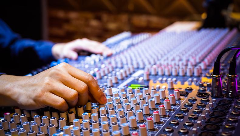 a man using a mixing board for audio production